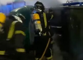 Bomberos de Palencia apagando el fuego de un contenedor.