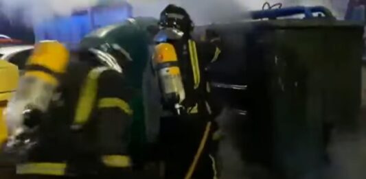 Bomberos de Palencia apagando el fuego de un contenedor.