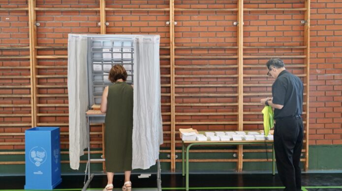 Persona votando en un centro electoral durante las elecciones generales en Palencia