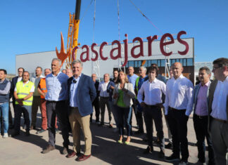 Responsables y trabajadores de Cascajares y de las empresas constructoras junto al cartel de Cascajares que sobrevivió al incendio y que se ha vuelto a recolocar en las nuevas instalaciones. / Brágimo (ICAL)