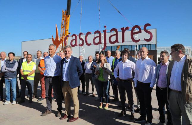 Responsables y trabajadores de Cascajares y de las empresas constructoras junto al cartel de Cascajares que sobrevivió al incendio y que se ha vuelto a recolocar en las nuevas instalaciones. / Brágimo (ICAL)