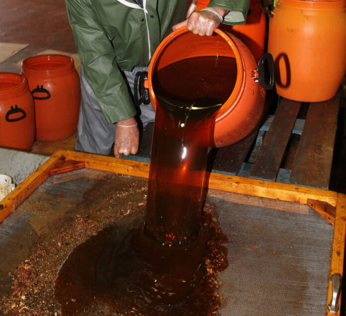 Un operario de la empresa encargada por el Ayuntamiento de Palencia para la recogida de aceite vegetal usado de Palencia vierte el contenido de lo recogido. / ICAL