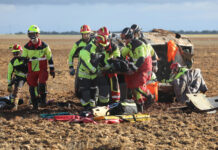 Bomberos de la capital (traje rojo y amarillo) y voluntarios de los parques de la Diputación (traje negro y amarillo) rescatan a una de las heridas en un accidente. / Brágimo (ICAL)