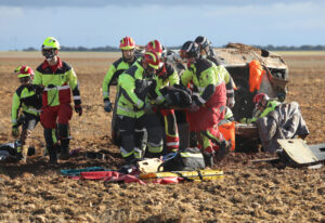 Bomberos de la capital (traje rojo y amarillo) y voluntarios de los parques de la Diputación (traje negro y amarillo) rescatan a una de las heridas en un accidente. / Brágimo (ICAL)