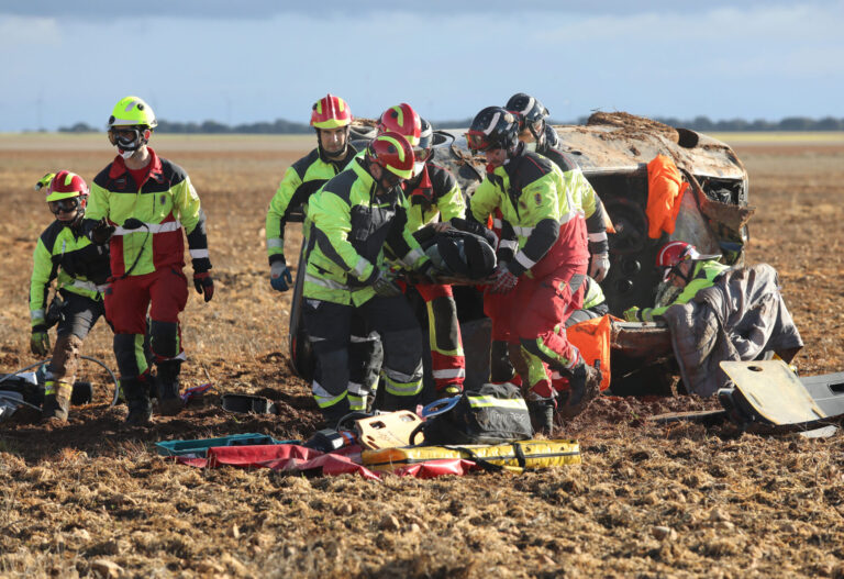 Bomberos de la capital (traje rojo y amarillo) y voluntarios de los parques de la Diputación (traje negro y amarillo) rescatan a una de las heridas en un accidente. / Brágimo (ICAL)