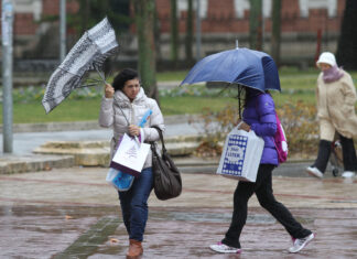 Temporal de viento y lluvia en Palencia. En la imagen unas mujeres sortean el agua y el viento en la plaza de la Pio XII de Palencia. / Brágimo (ICAL)