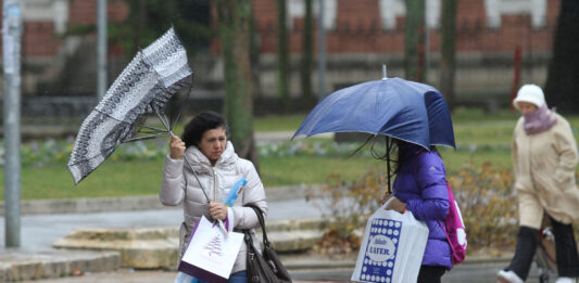 Temporal de viento y lluvia en Palencia. En la imagen unas mujeres sortean el agua y el viento en la plaza de la Pio XII de Palencia. / Brágimo (ICAL)