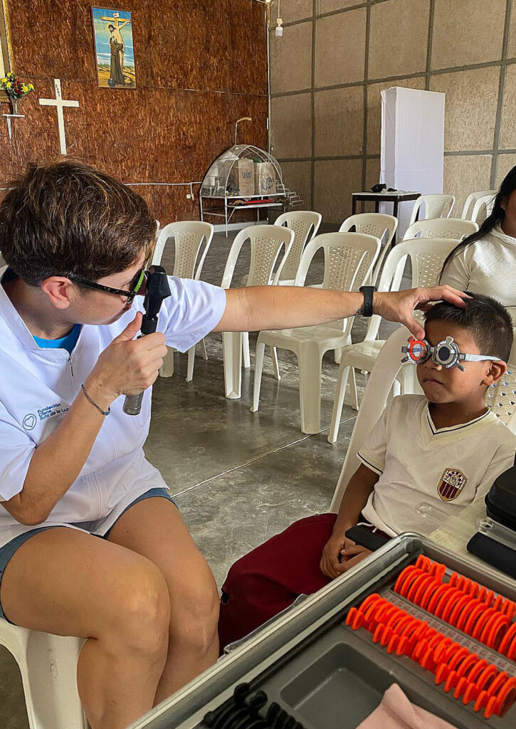 La integrante de Palentinas por Perú, la optometrista Vicki Alonso revisa la vista un niño de Paita, región de Piura de Perú