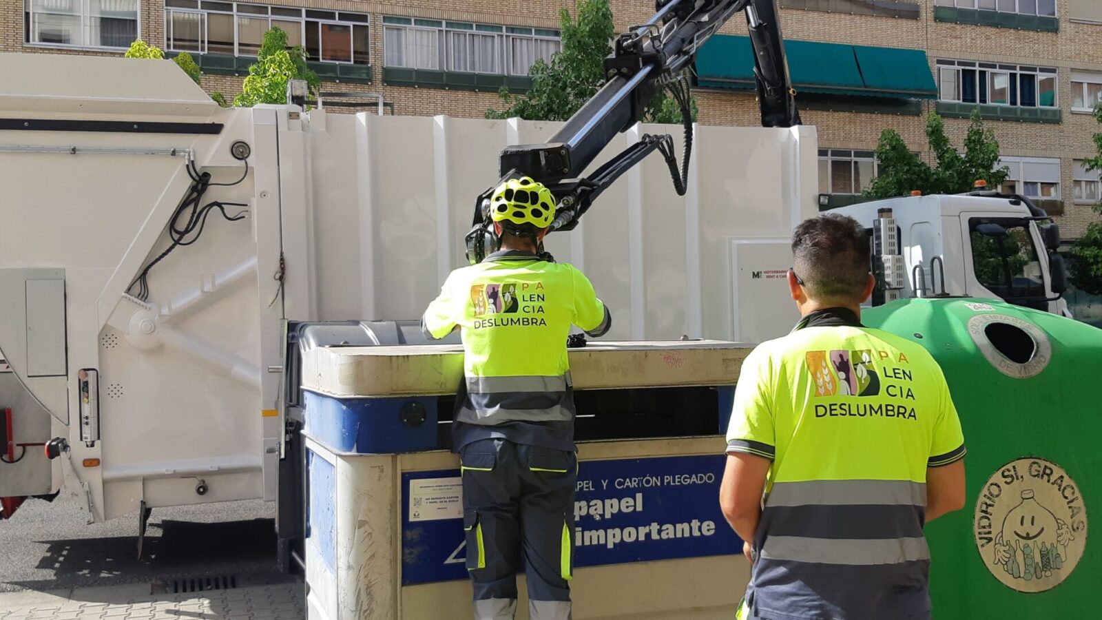 Operarios de Palencia Deslumbra recogiendo esta tarde los contenedores de cartón en la zona de Cardenal Cisneros. / Óscar Herrero