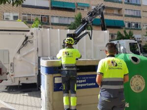 Operarios de Palencia Deslumbra recogiendo esta tarde los contenedores de cartón en la zona de Cardenal Cisneros. / Óscar Herrero