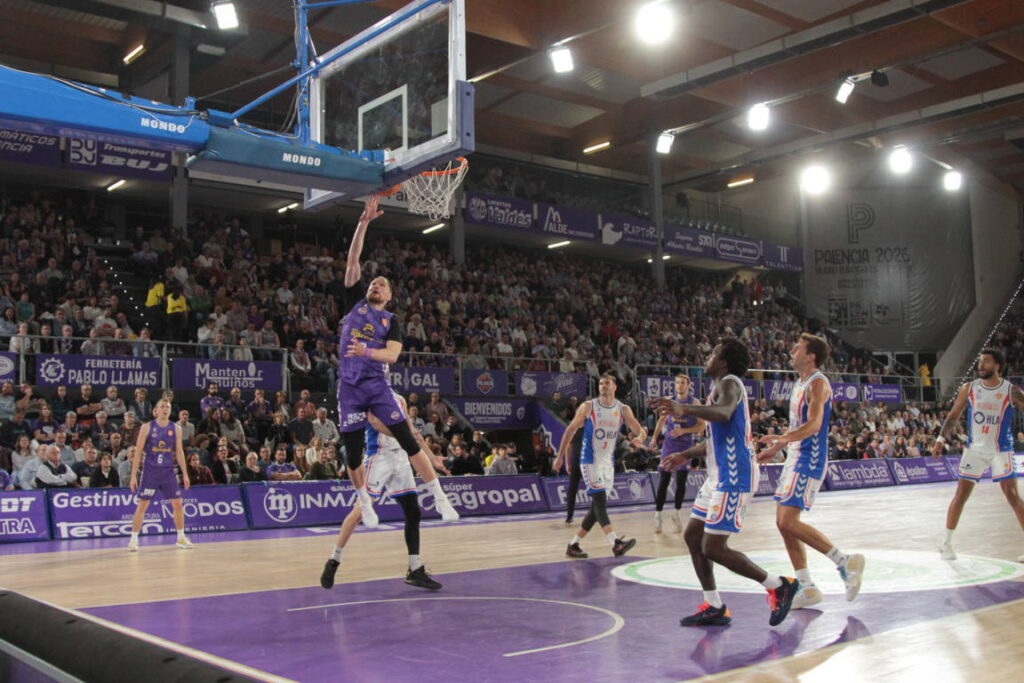 Jugador saltando para encestar durante un partido de baloncesto