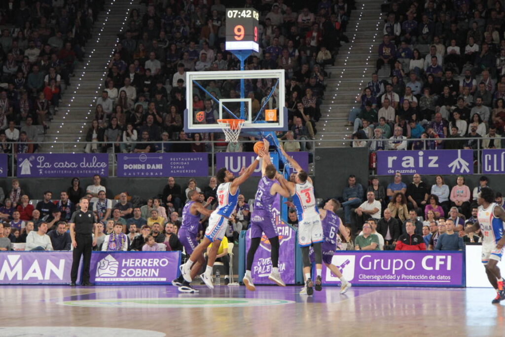 Jugadores en acción durante un partido de baloncesto entre Palencia y Alicante.