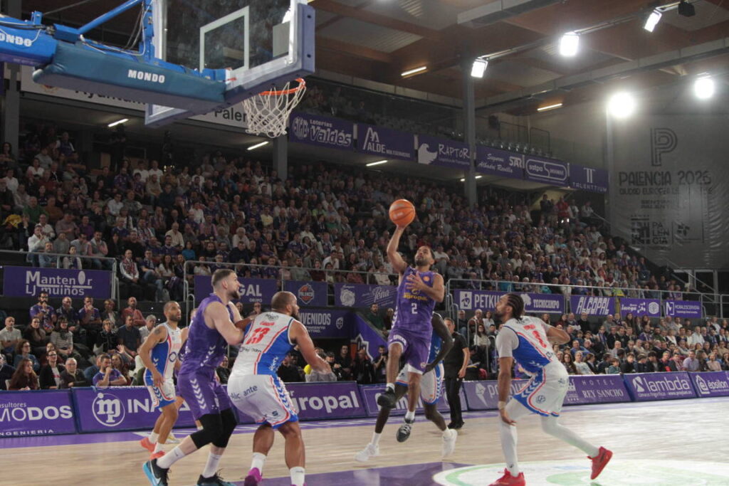 Jugador de baloncesto lanzando a canasta en un partido entre Palencia y Alicante.