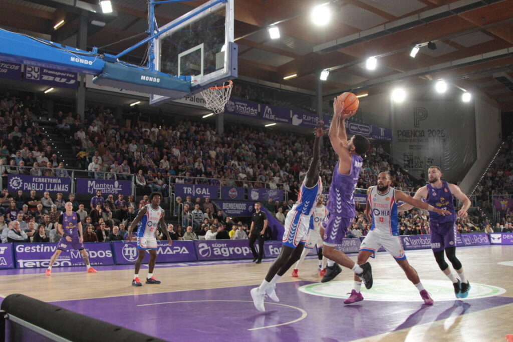 Jugador lanzando a canasta durante un partido de baloncesto en Palencia