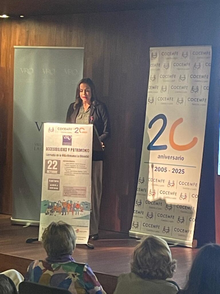 Mujer hablando en un evento de COCEMFE en la Villa Romana de La Olmeda.