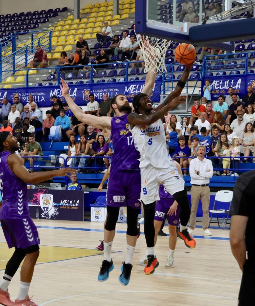 Jugadores de baloncesto en acción durante un partido entre Palencia y Melilla.