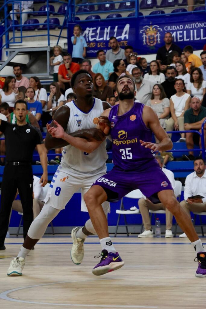 Jugadores de baloncesto compitiendo en un partido entre Súper Agropal Palencia y Melilla.