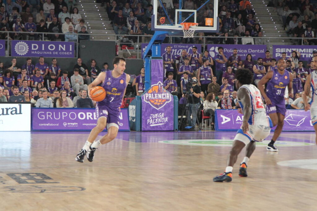 Jugador del equipo de baloncesto de Palencia con balón en la cancha