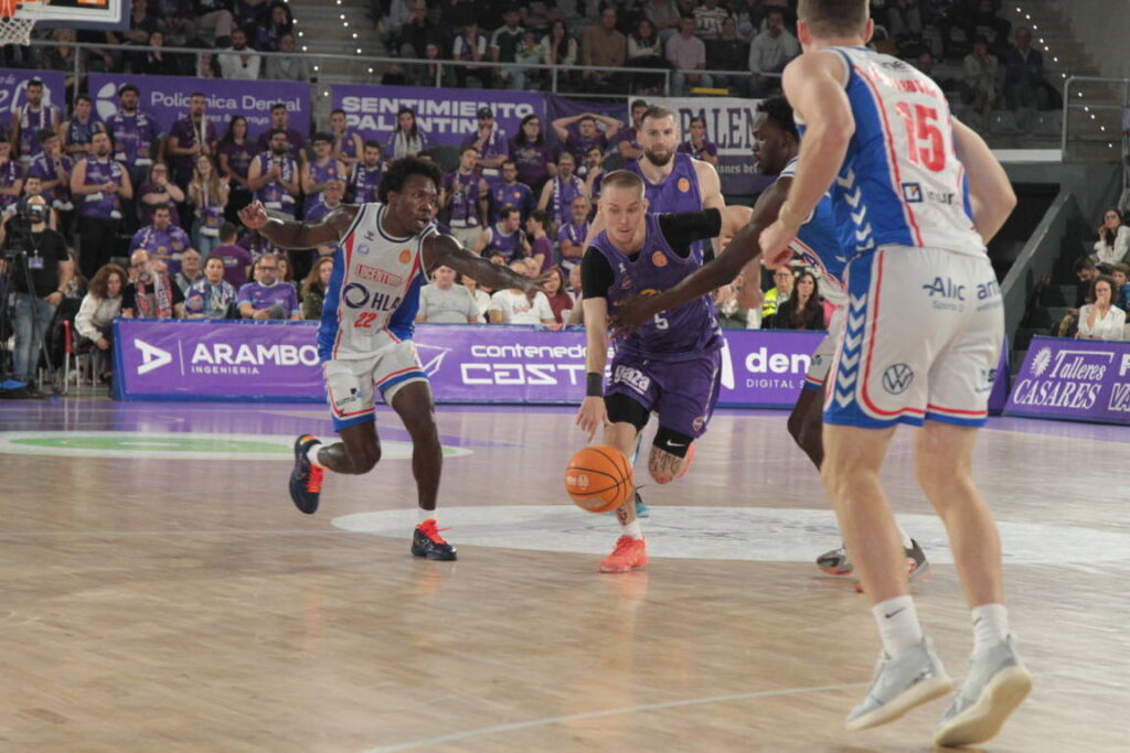 Jugadores de baloncesto compitiendo en un partido entre Palencia y Alicante
