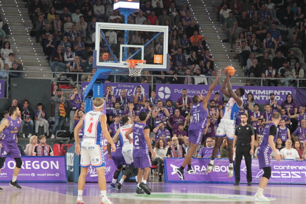 Jugadores de baloncesto compitiendo en un partido entre Palencia y Alicante.