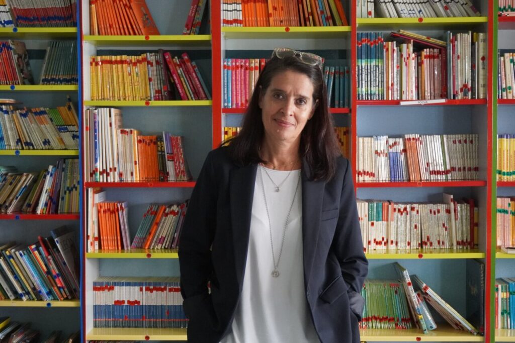 Mar Romera posando frente a estanterías llenas de libros en una biblioteca.