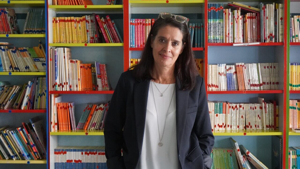 Mar Romera posando frente a estanterías llenas de libros en una biblioteca.