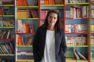 Mar Romera posando frente a estanterías llenas de libros en una biblioteca.