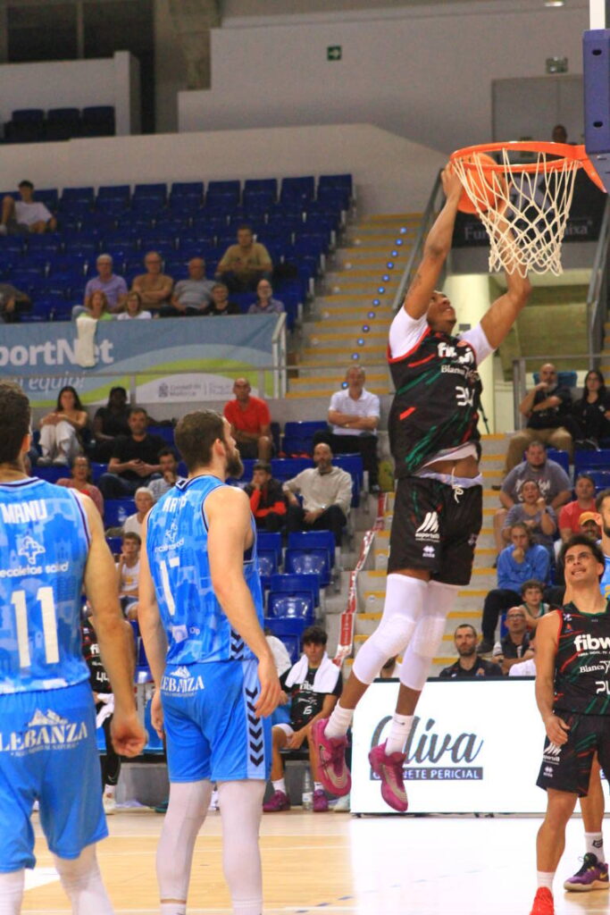 Jugador de baloncesto realizando un mate en un partido