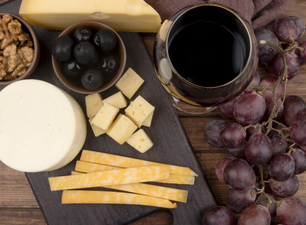 Tabla de quesos y vino tinto con uvas y nueces
