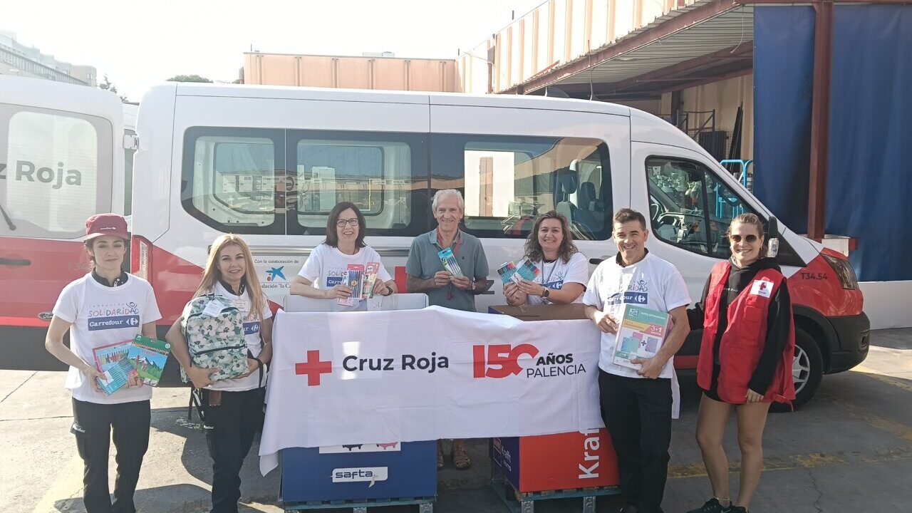 Voluntarios de Cruz Roja entregando material escolar en Palencia