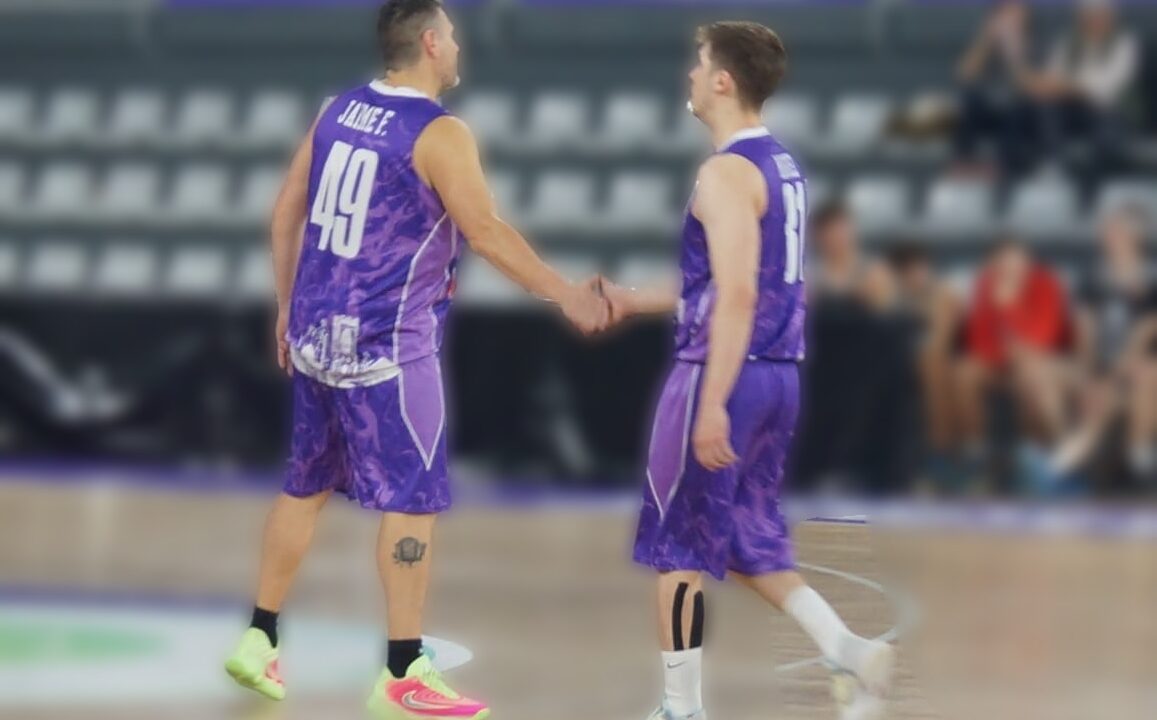 Jugadores de baloncesto saludándose en la cancha durante un partido