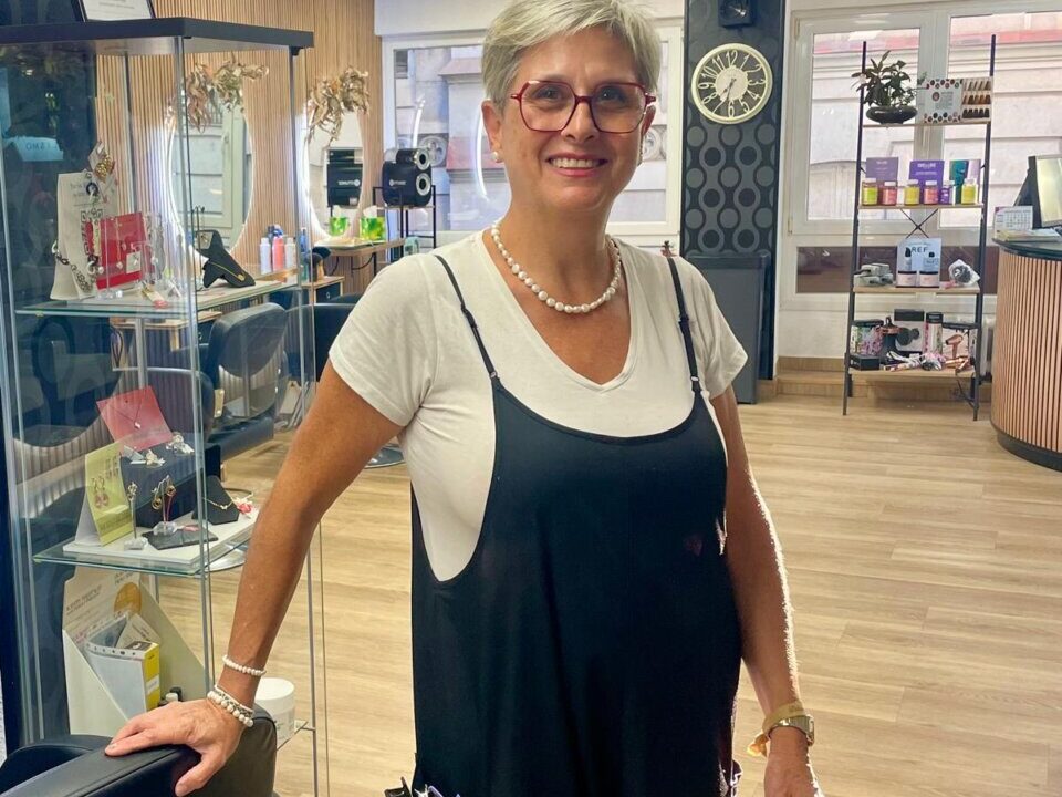 Chus Sastre en su peluquería en Palencia, sonriendo y con un look profesional.