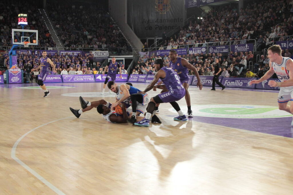 Jugadores de baloncesto compiten por el balón en la cancha de Palencia.