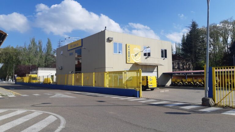 Edificio de Correos en Palencia con vehículos amarillos estacionados