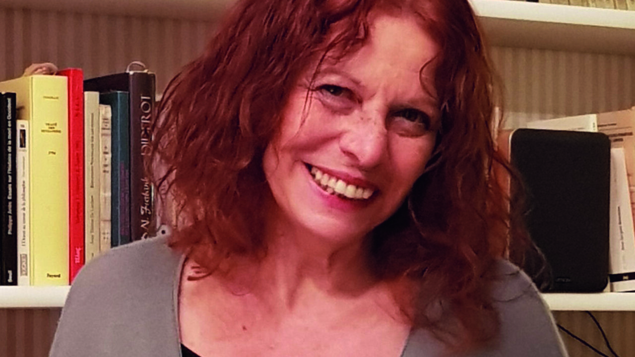 Alicia Puleo sonriendo frente a una estantería con libros