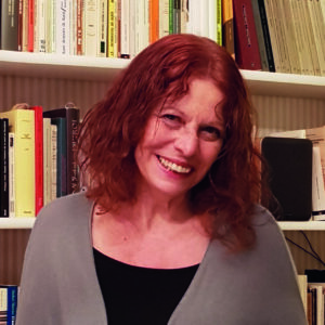 Alicia Puleo sonriendo frente a una estantería con libros