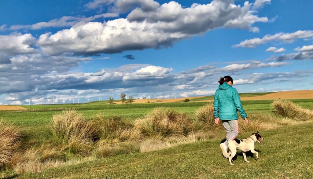 Eva Pastor caminando con su perro en un paisaje rural