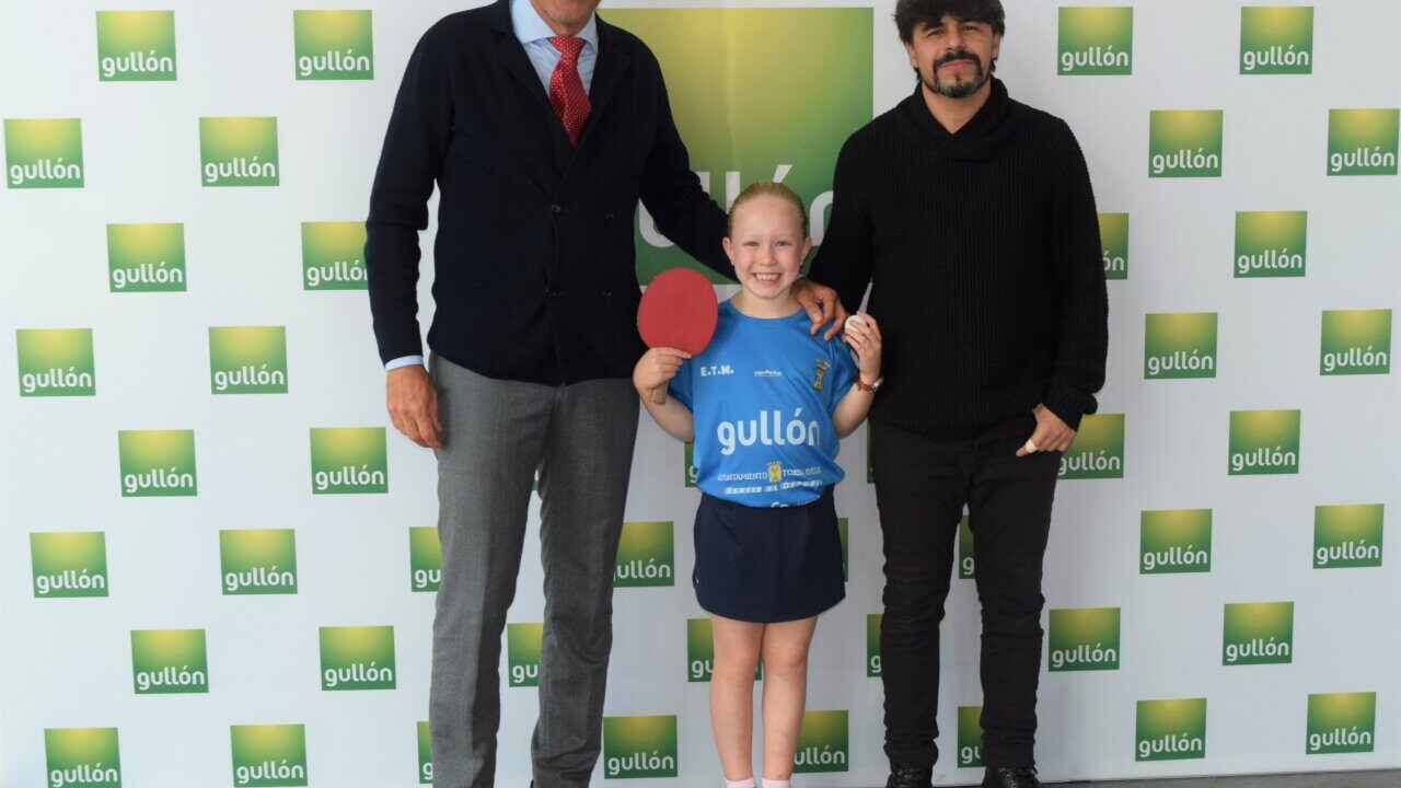 Nerea Hidalgo, campeona de tenis de mesa, con dos hombres en evento de apoyo.