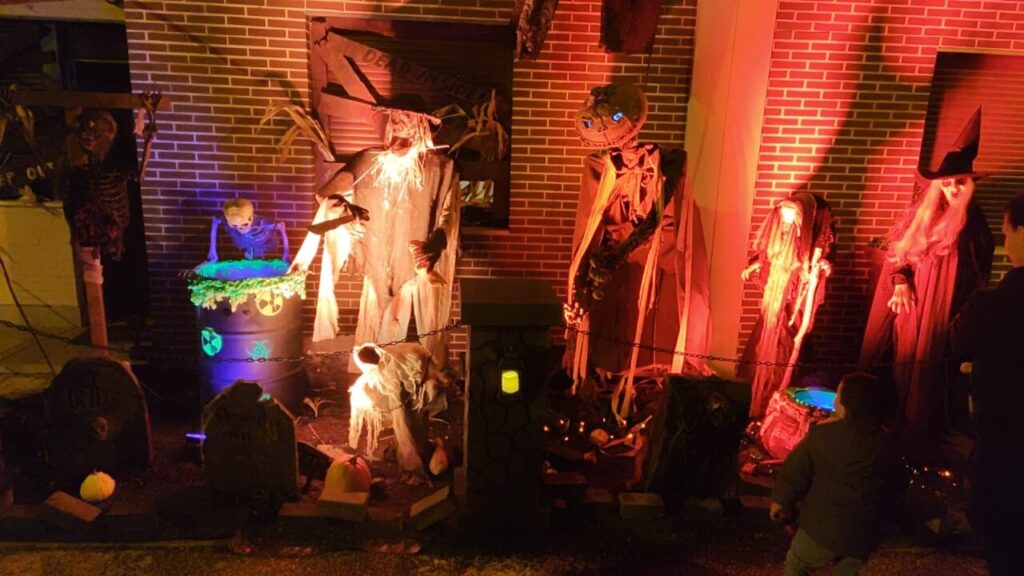 Decoraciones de Halloween en un pasaje del terror con esqueletos y brujas.