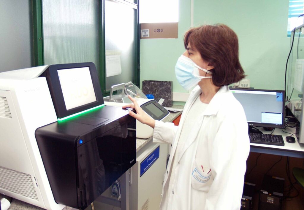 Investigadora en laboratorio utilizando un equipo de análisis de datos