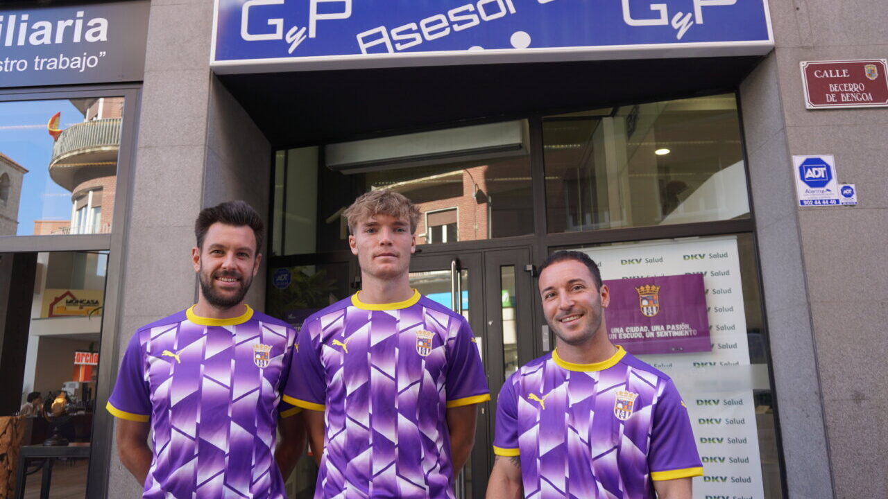 Tres personas posando frente a GyP Asesores con camisetas moradas