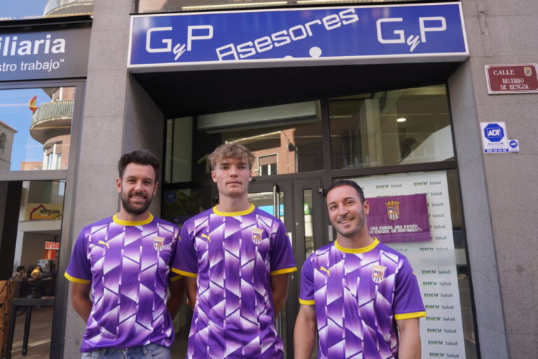 Tres personas posando frente a GyP Asesores con camisetas moradas