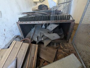 Interior de una quesería abandonada con escombros y chatarra