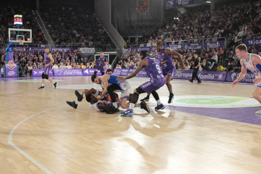 Jugadores de baloncesto en una intensa jugada en el partido Palencia contra Alicante.