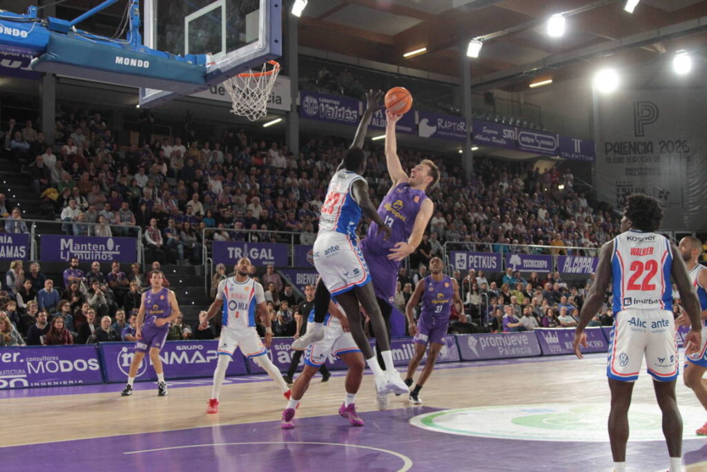 Jugador en acción durante un partido de baloncesto entre Palencia y Alicante.