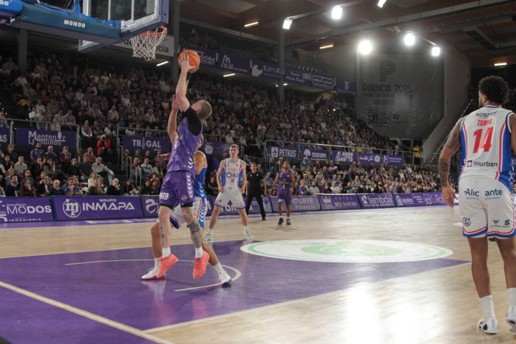 Jugador lanzando a canasta en un partido de baloncesto entre Palencia y Alicante.