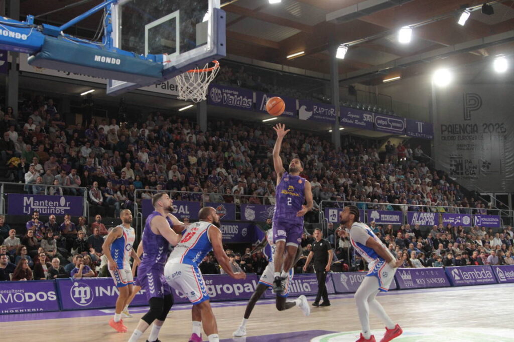 Jugador del Súper Agropal Palencia lanzando a canasta en un partido de baloncesto.