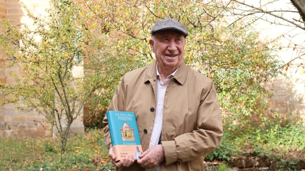 José María Pérez Peridis sosteniendo su libro en un evento cultural.