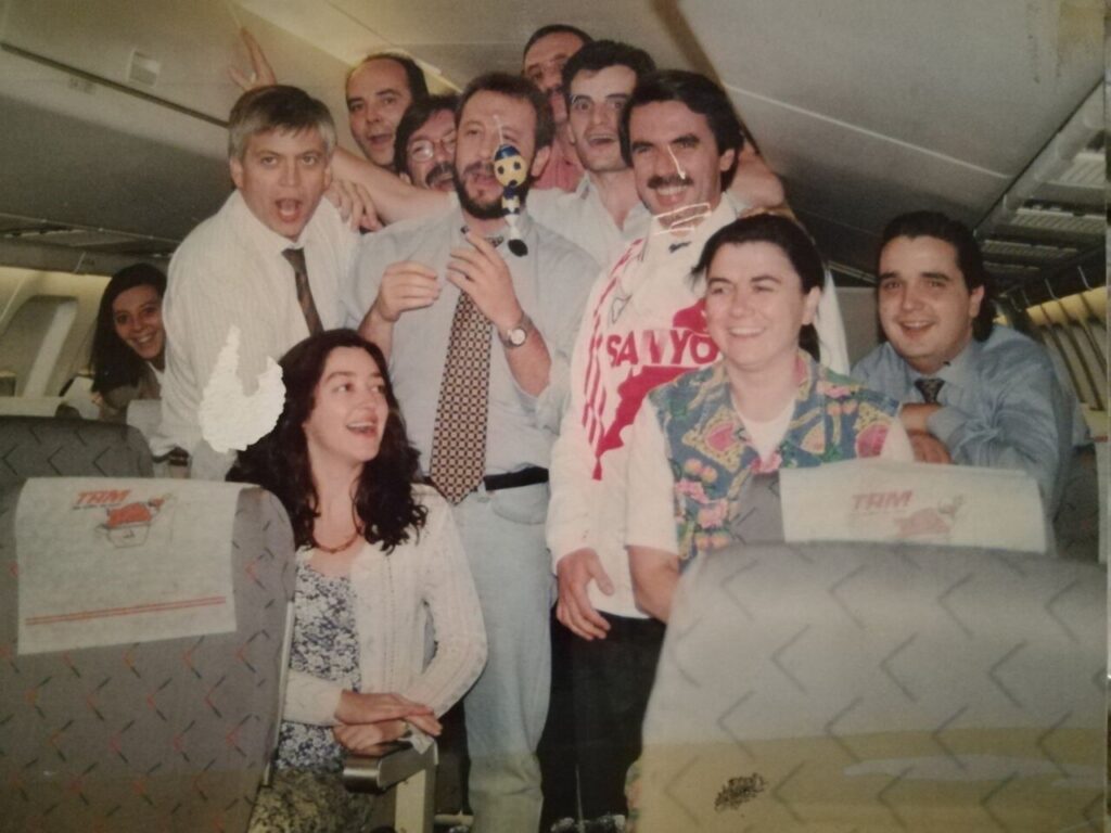Grupo de periodistas sonrientes en un avión durante un viaje