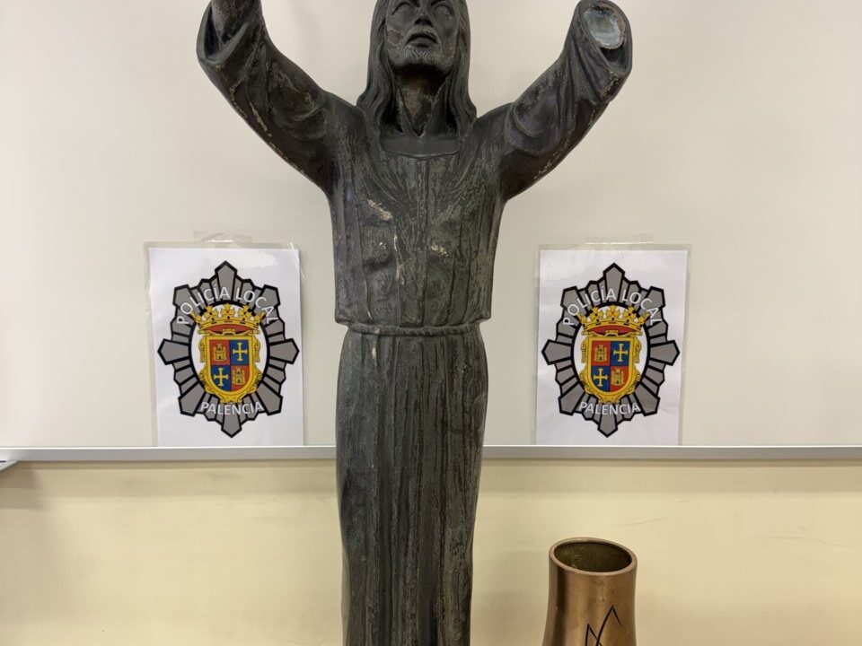 Escultura de un Cristo con los brazos levantados en un fondo neutro